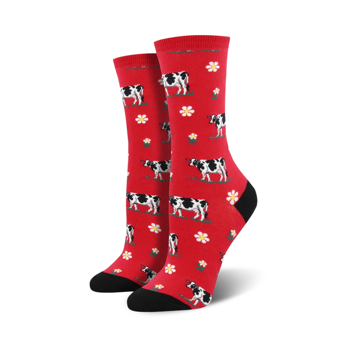 Pair of crew socks; red background with black and white cows and white flowers.  Black heel and toe.