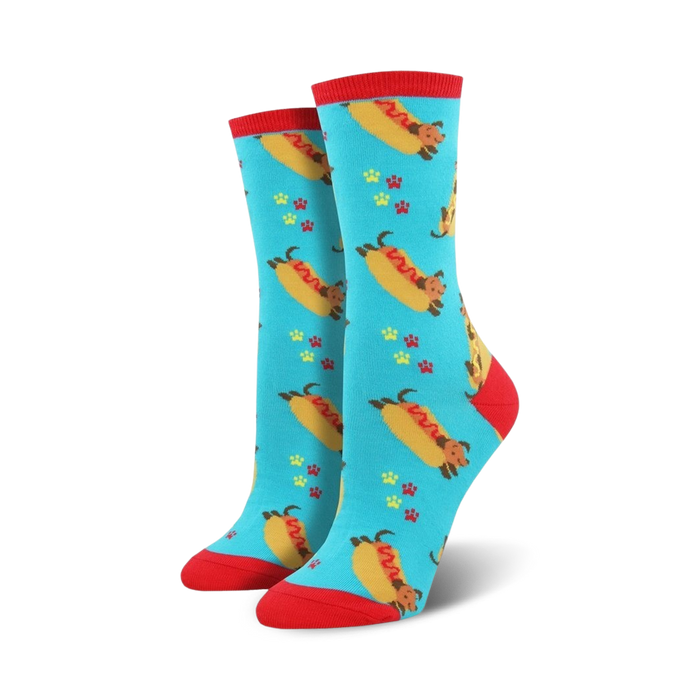 Pair of women's crew socks. Teal background with dachshunds shaped like hot dogs, red paw prints. Red top trim. }}