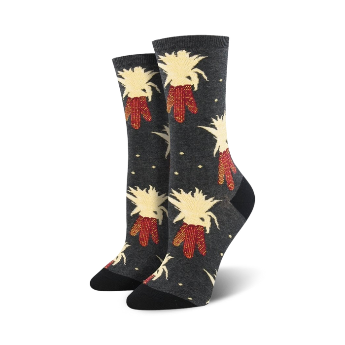Pair of women's crew socks in dark grey and navy blue, featuring a whimsical pattern of illustrated corn stalks with red and beige details.