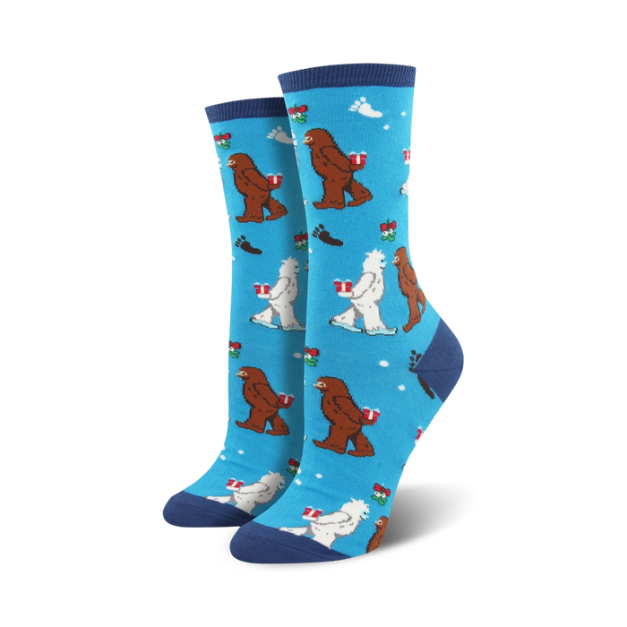 Crew socks in blue, green, and red featuring Bigfoot and Yeti characters carrying gifts on a snowflake background.