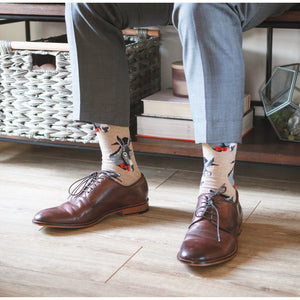 Lifestyle shot: A person wearing tan donkey socks with brown leather shoes.