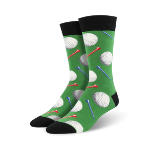 Pair of crew socks with a golf theme. Green background features white golf balls and red and blue tees. Black cuff and sole.