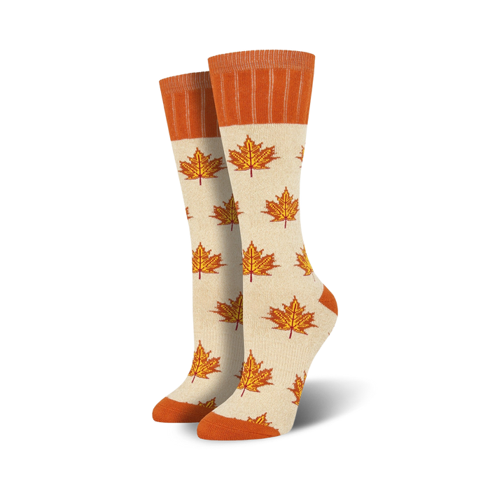 Pair of cream crew socks with orange maple leaf pattern. Orange ribbed cuff. }}