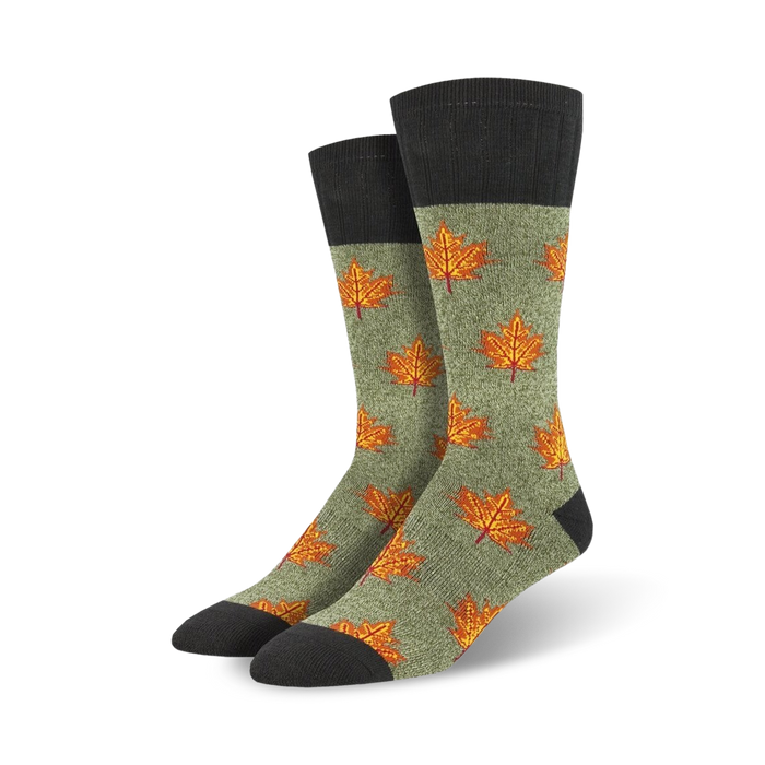 Pair of crew socks in olive green with orange maple leaf pattern and dark gray cuffs. Autumn-themed design.