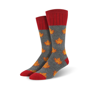 Close-up showing detail of gray crew socks with orange maple leaf pattern and red cuffs.