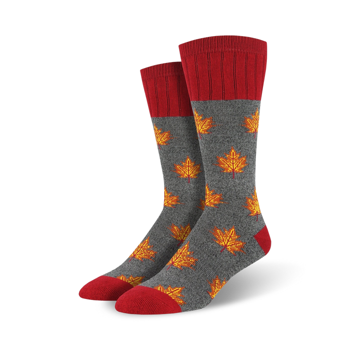 Close-up showing detail of gray crew socks with orange maple leaf pattern and red cuffs.