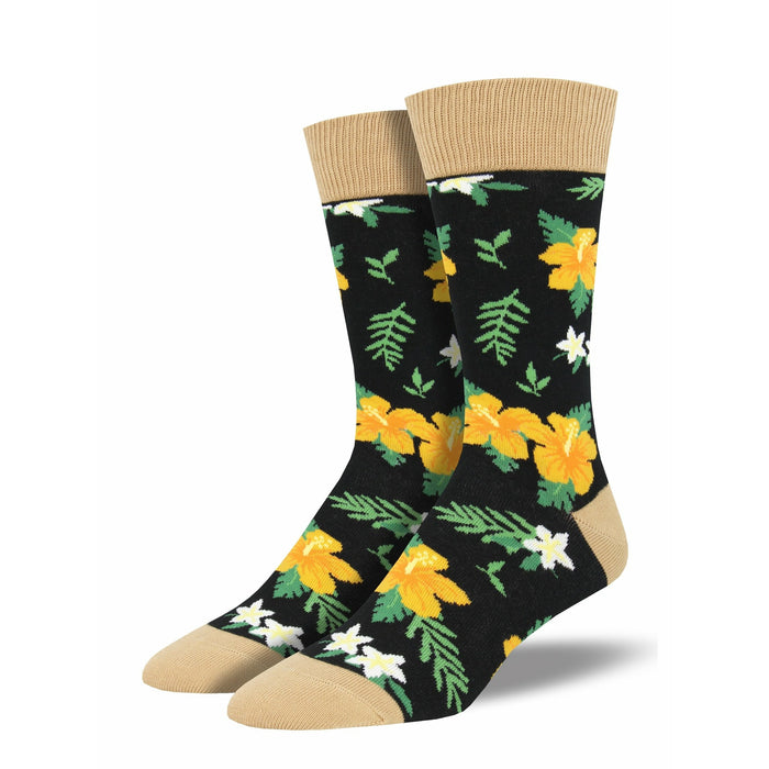 Pair of black crew socks with a bold yellow hibiscus and white flower pattern, tan cuff.