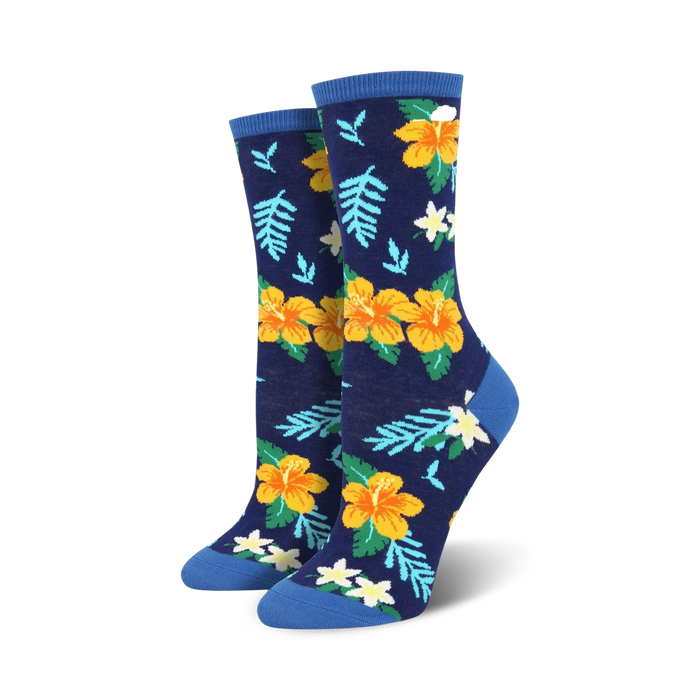 Pair of women's crew socks in navy blue, featuring yellow and orange hibiscus flowers and green leaves.  Blue cuffs.