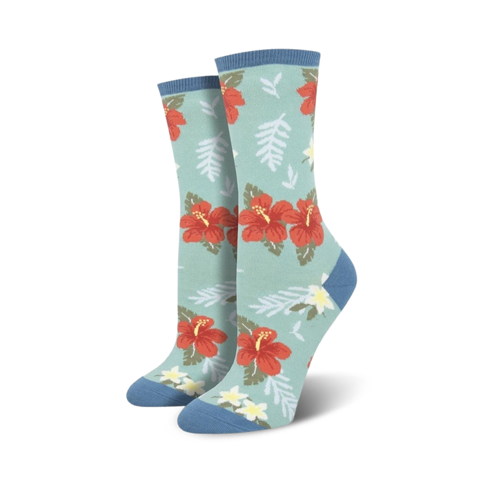 Close-up showing the detail of the red hibiscus flower and green leaf design on a teal crew sock.