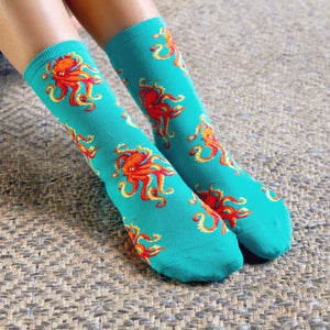 Close-up of teal crew socks with red octopus design.