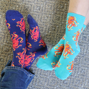 Two people's feet wearing teal and black octopus socks.
