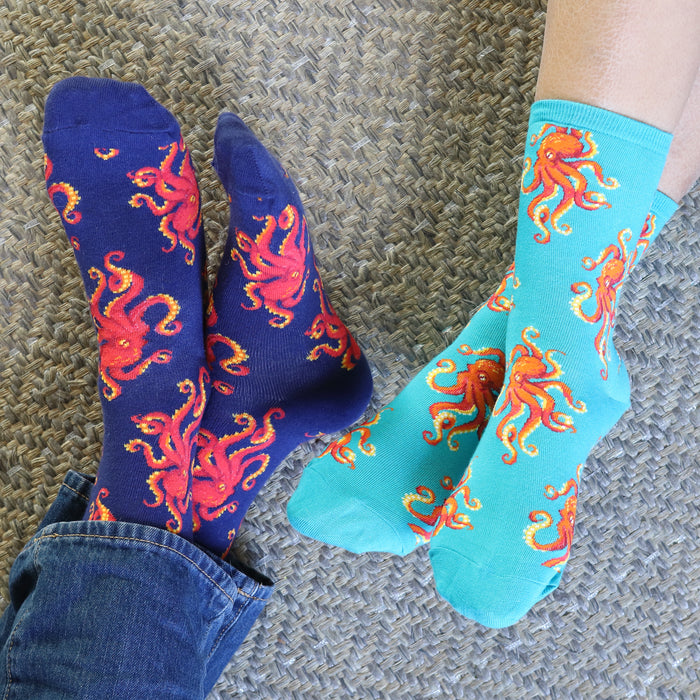 Two people's feet wearing teal and black octopus socks.