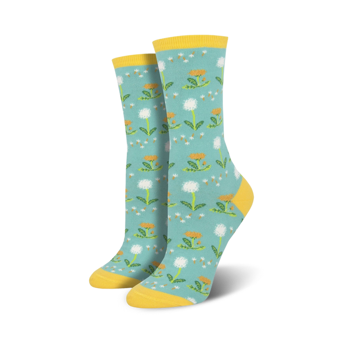 Pair of crew socks, teal background with white dandelions and yellow accents. Yellow cuff.