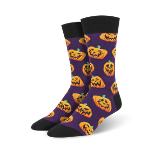 Pair of crew socks; purple background with orange grinning pumpkins; black cuff.