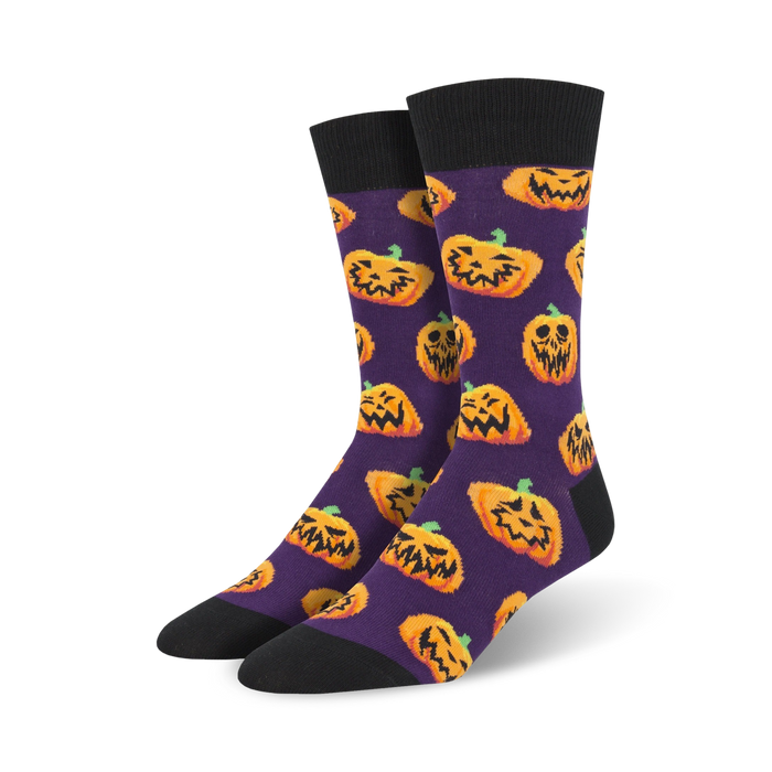 Pair of crew socks; purple background with orange grinning pumpkins; black cuff.