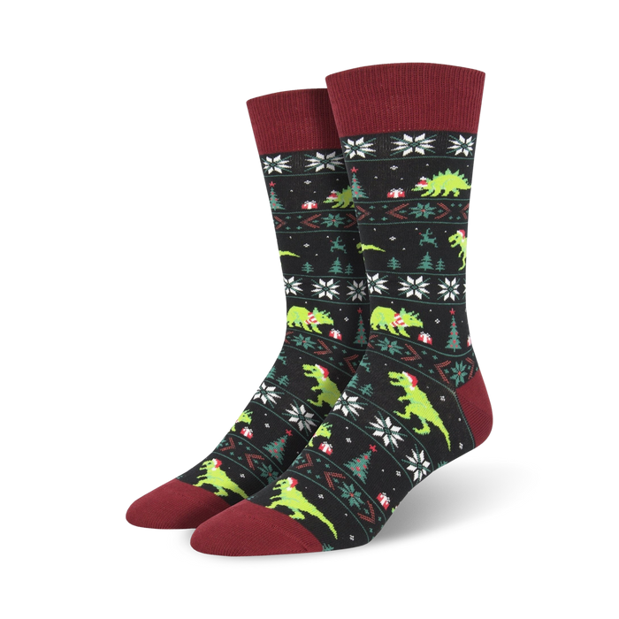 Pair of crew socks, black and green, featuring a Christmas-themed pattern with dinosaurs wearing Santa hats.