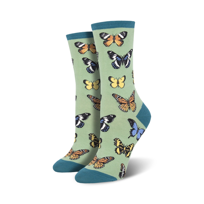 Pair of women's crew socks in sage green with a colorful butterfly pattern.
