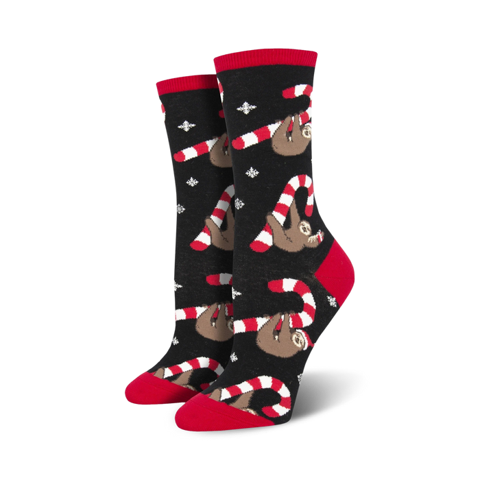Pair of women's crew socks. Black background with red and white candy canes and brown sloths. Festive and fun!