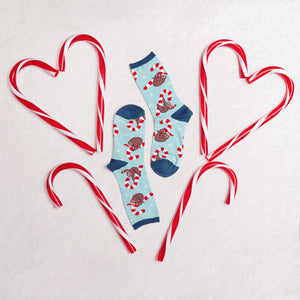 Close-up detail shot of the Merry Slothmas socks, showcasing the sloth and candy cane pattern.
