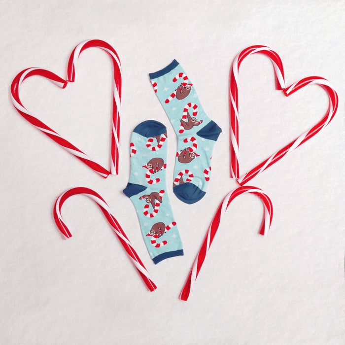 Close-up detail shot of the Merry Slothmas socks, showcasing the sloth and candy cane pattern.