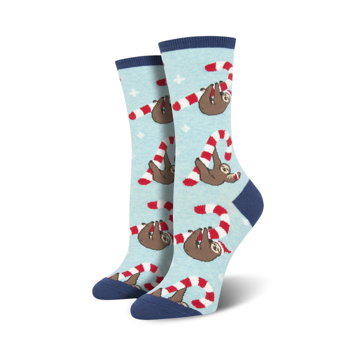 Lifestyle flat lay photo showing a pair of light blue Merry Slothmas socks surrounded by candy canes shaped into hearts.