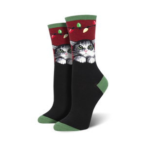 Lifestyle shot showing the socks on a person's feet, highlighting the festive design and cat illustration.