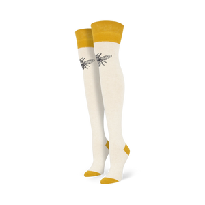 Pair of off-white knee-high socks with mustard yellow cuffs and a small, dark bee graphic on each sock.