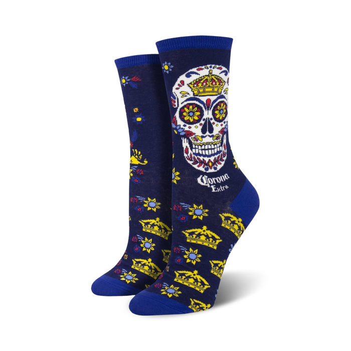 Women's crew socks in navy blue, featuring a colorful sugar skull with a crown, gold crowns, and floral details. Corona Extra logo is visible. }}