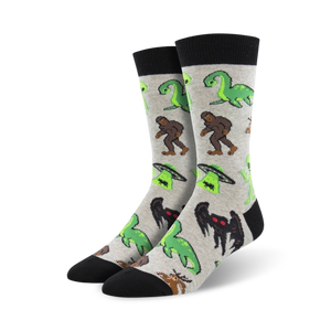 Pair of crew socks in grey and black, featuring a fun print of various cryptids including Bigfoot, Nessie, and aliens.