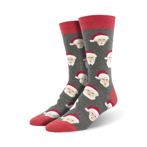 Close-up view of a pair of grey crew socks with a repeating pattern of a white-haired Santa Claus wearing a red hat.