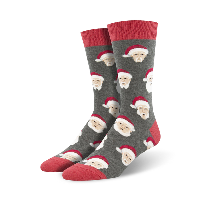 Close-up view of a pair of grey crew socks with a repeating pattern of a white-haired Santa Claus wearing a red hat.