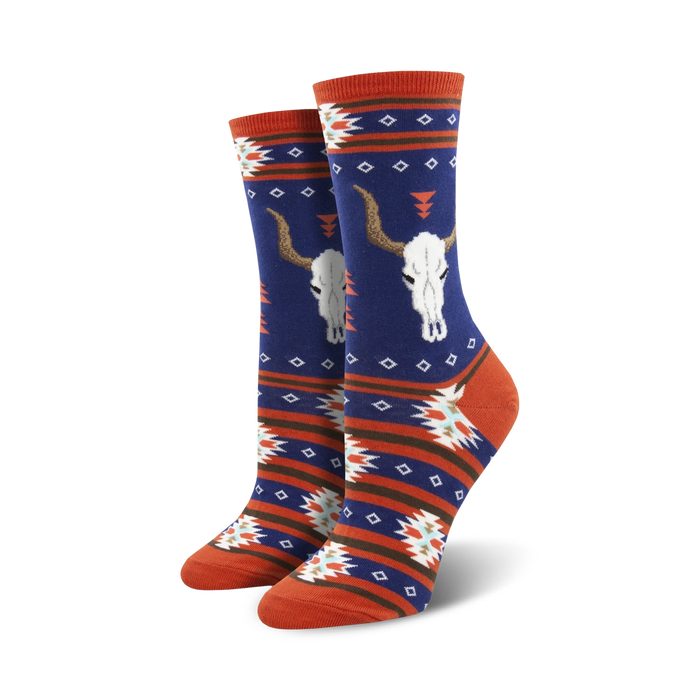 Close-up view of a pair of navy blue and orange crew socks with the same longhorn skull and southwestern pattern design.