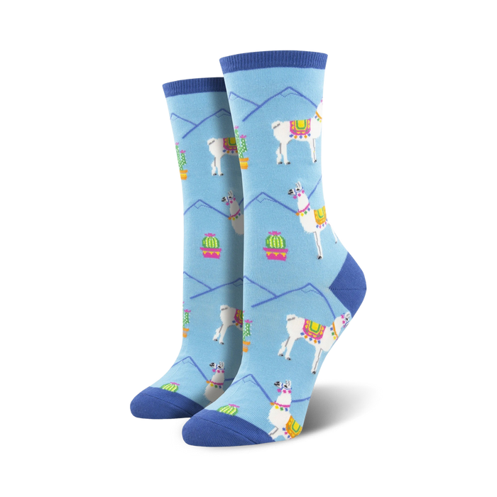 Pair of women's crew socks in light blue. Features a repeating pattern of white llamas with colorful saddles, cacti in pink pots, and light blue mountains. }}