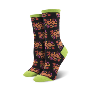 A pair of black crew socks with the same jack-o'-lantern design, but on a black background with lime green cuffs.