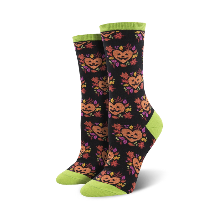 A pair of black crew socks with the same jack-o'-lantern design, but on a black background with lime green cuffs.