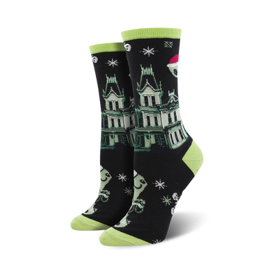 A pair of black crew socks with a green haunted house, ghosts wearing Santa hats, and snowflakes. Lime green cuffs.