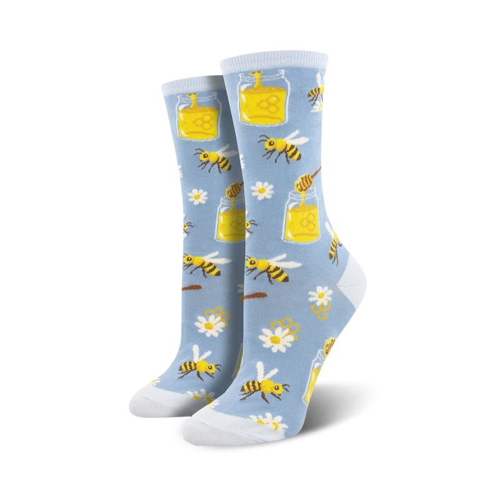 Pair of women's crew socks in light blue and orange. The socks feature a whimsical design of bees, honey jars, daisies and honeycomb.