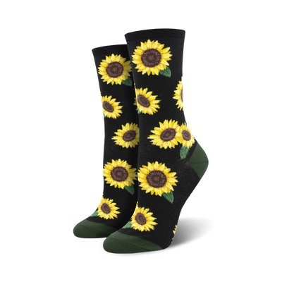 A pair of crew socks with a sunflower pattern. The socks are black with yellow sunflowers and green leaves, and have dark green cuffs.