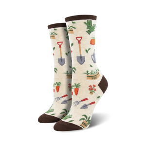 Pair of cream and green crew socks with a whimsical gardening theme.  The design includes carrots, flowers, shovels, and watering cans.
