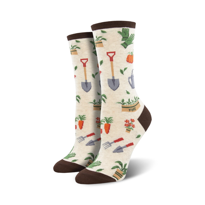 Pair of cream and green crew socks with a whimsical gardening theme.  The design includes carrots, flowers, shovels, and watering cans.