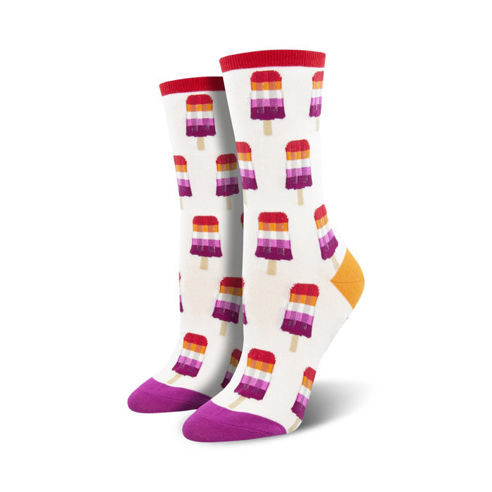 Pair of crew socks with a white background and repeating pattern of lesbian flag-colored popsicles.  Red, orange, purple, and white popsicle design; purple and orange heel and toe.