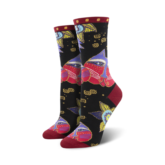 A pair of women's crew socks in black with a colorful design. The main pattern features stylized cat faces in shades of red, purple, and gold, along with smaller floral and geometric details. }}