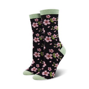 Pair of women's crew socks in black with pink cherry blossom design and light green cuffs.
