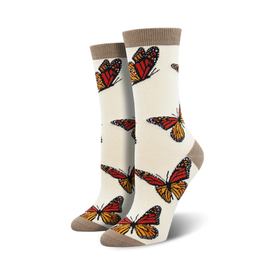 Pair of cream women's crew socks adorned with orange and brown monarch butterfly prints.  Features a subtle taupe cuff.