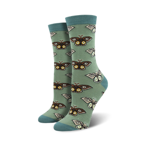 Close-up of a pair of sage green crew socks with a repeating pattern of brown and cream moths. Soft bamboo fabric.