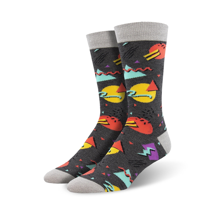 Pair of crew socks with a 90s-inspired geometric print.  Colors include teal, orange, yellow, purple, and grey on a dark grey background. }}