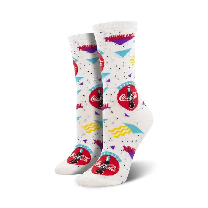 Pair of white crew socks with a 90s-themed Coca-Cola design. Red Coca-Cola logo, teal and purple accents, and wavy lines on a white background. }}