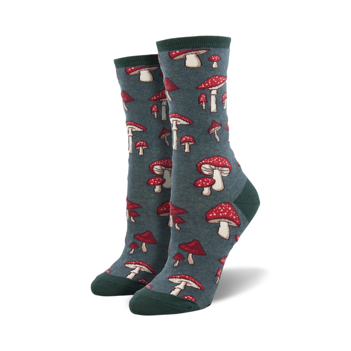 Pair of crew socks with a whimsical mushroom pattern. The socks are teal and feature red and white mushrooms.