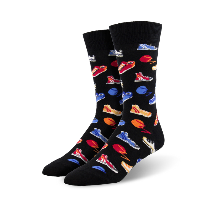 Pair of black crew socks with a colorful sneaker print. The sneakers are red, blue, orange, and white on a black background. }}