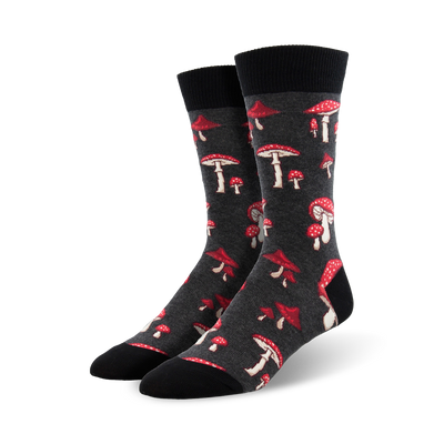 A pair of dark grey crew socks adorned with a scattered pattern of red and white mushrooms. Fun and quirky!